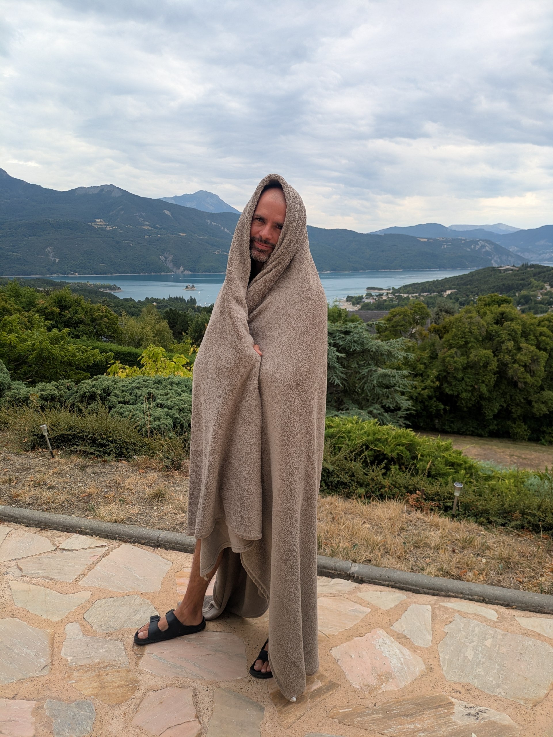 Kimono Sherpa Zen taupe à capuche, très enveloppant, devant un lac de montagne