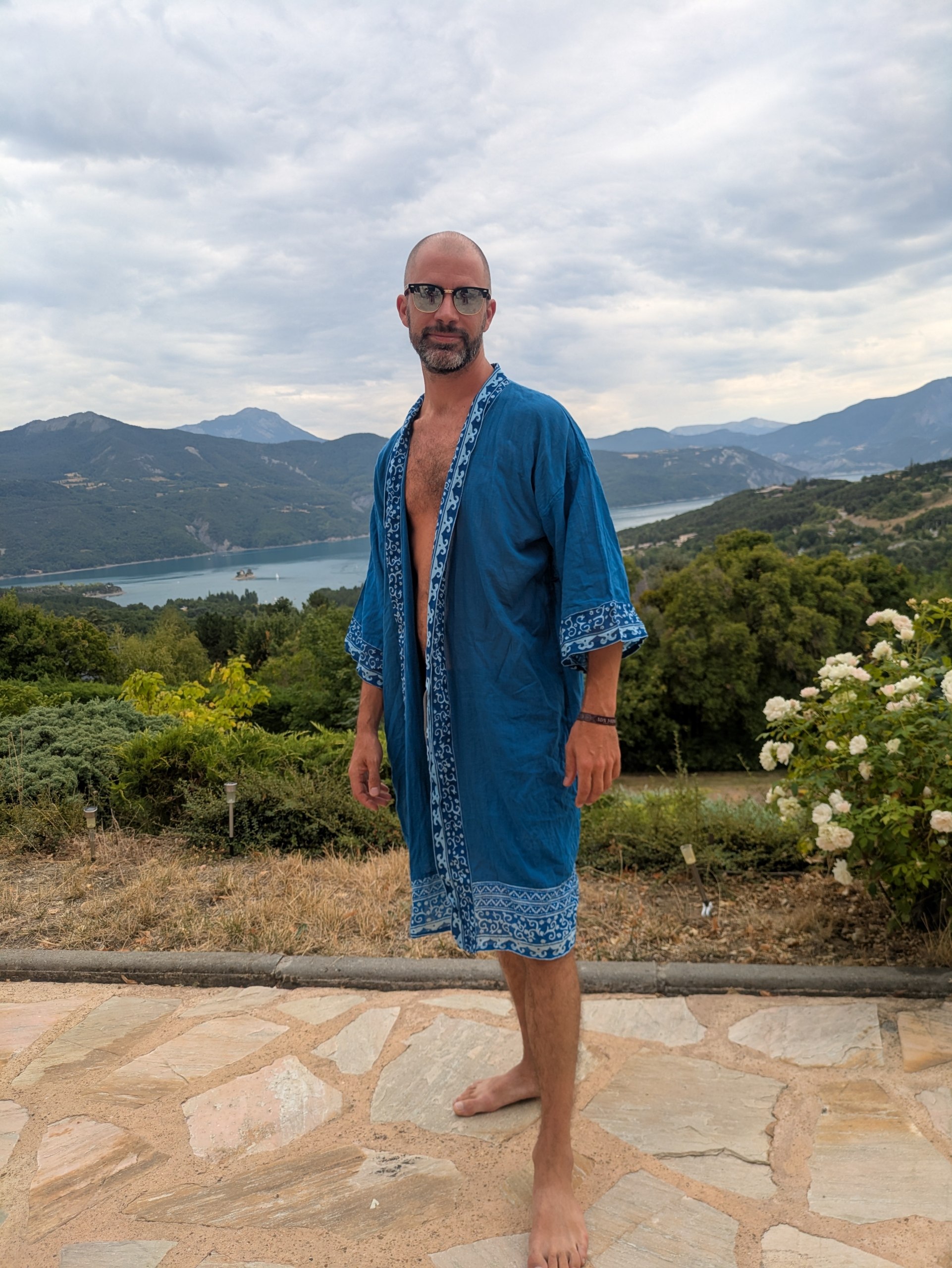 Kimono Riviera bleu indigo à liseré blanc, porté face à un lac de montagne